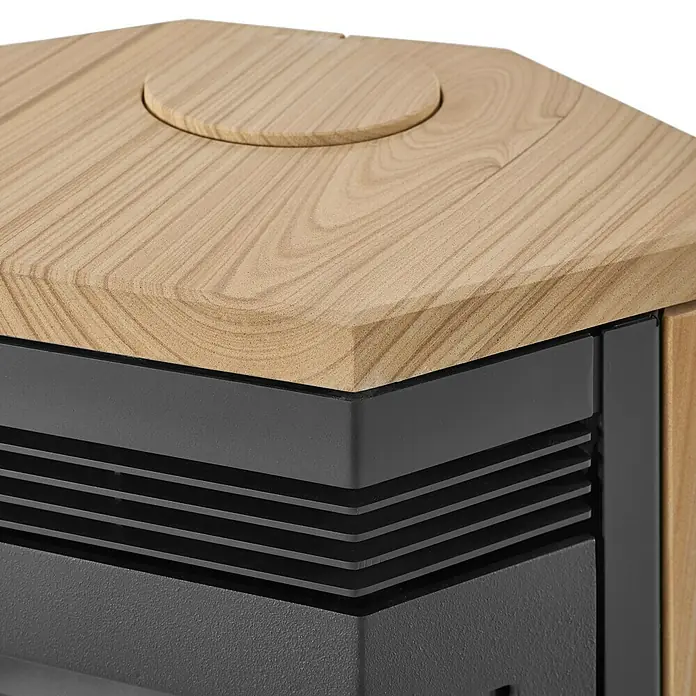 Justus Kaminofen Usedom 5 II - 5,5 kW, Raumheizvermögen: 88 m³, Material Verkleidung: Sandstein, Sandstein/Schwarz - Nahaufnahme eines Pelletofens mit Holzplatte und Lüftungsschlitzen, der Wärme und Stil vereint.