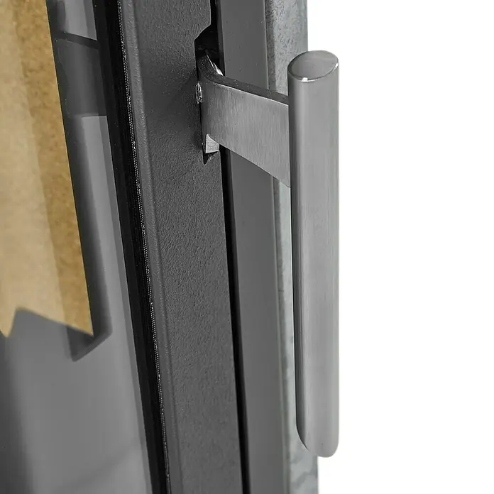 Justus Kaminofen Usedom 5 II - 5,5 kW, Raumheizvermögen: 88 m³, Material Verkleidung: Speckstein, Schwarz/Speckstein - Nahaufnahme eines Ofens mit einem eleganten, langen Griff aus gebürstetem Stahl, der das moderne Design des Produkts hervorhebt.