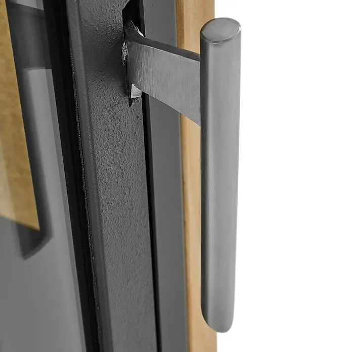 Justus Kaminofen Usedom 5 II - 5,5 kW, Raumheizvermögen: 88 m³, Material Verkleidung: Sandstein, Sandstein/Schwarz - Nahaufnahme eines grauen Türgriffs. Der Türgriff ist aus Metall und hat eine zylindrische Form.