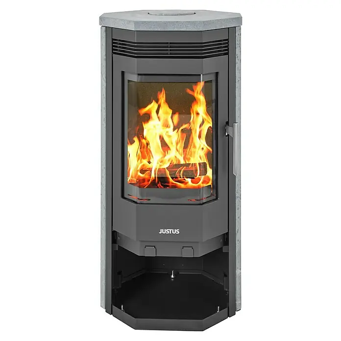 Justus Kaminofen Usedom 5 II - 5,5 kW, Raumheizvermögen: 88 m³, Material Verkleidung: Speckstein, Schwarz/Speckstein - Ein Justus Kaminofen mit einem lodernden Feuer im Inneren, das durch eine Glasscheibe sichtbar ist. Die Verkleidung besteht aus Stein.