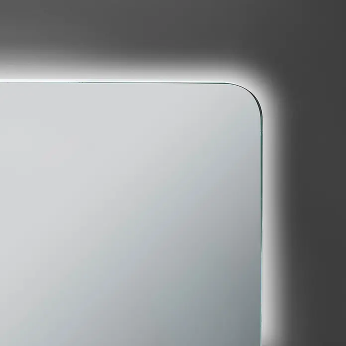 Camargue Lichtspiegel Romulo60 x 70 cm, Leuchtmittel - Nahaufnahme eines beleuchteten rechteckigen Spiegels mit abgerundeten Ecken, der an einer grauen Wand montiert ist.