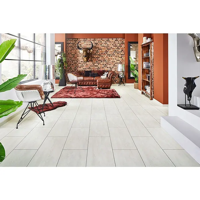 LOGOCLIC Laminatmuster Ceramico Bright Powder - 297 x 195 x 1 mm, Fliesenoptik - Einladendes Wohnzimmer mit weißen Fliesenböden, einem Ledersofa und industriellen Akzentstühlen. Die Backsteinmauer und das Geweih verleihen rustikalen Charme.