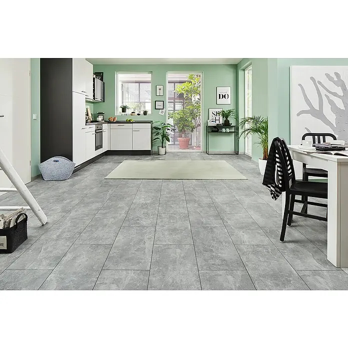 LOGOCLIC Laminatmuster Ceramico Luzzi - 297 x 195 x 1 mm, Fliesenoptik - Ein moderner Küchenraum mit grauen Bodenfliesen, weißen Küchenschränken und einem hellen Teppich in der Mitte des Raumes.