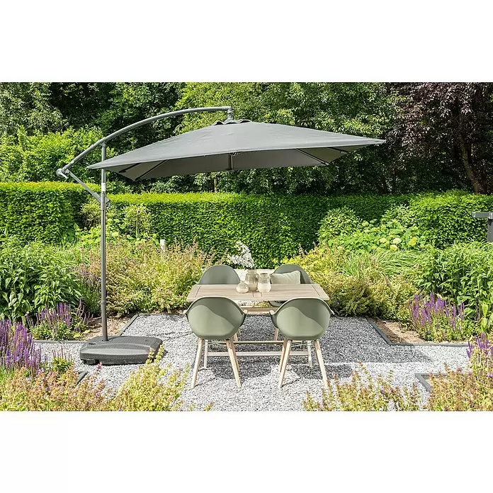 Garden Impressions Ampelschirm Corfu - Dunkelgrau, Bespannungsmaß (L x B): 250 x 250 cm - Grauer Ampelschirm beschattet eine Holzesstischgruppe mit vier grünen Stühlen auf Kies.