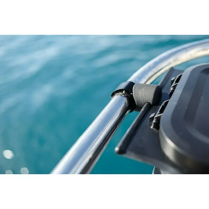 Yachticon Flextrash Rohrhalterung - Passend für: Yachticon Mülleimer Flextrash - Nahaufnahme einer Halterung für ein Gerät, die an einem verchromten Rohr befestigt ist, mit blauem Wasser im Hintergrund.