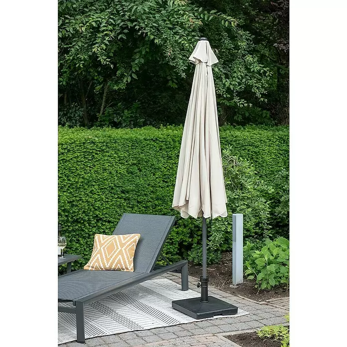 Garden Impressions Marktschirm rund Delta - Ecru, Durchmesser Bespannung: 300 cm - Geschlossener beiger Sonnenschirm mit dunklem Fuß, auf einer gepflasterten Terrasse für den Sonnenschutz.