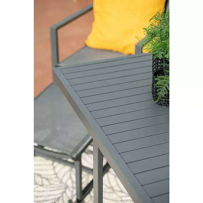 Garden Impressions Balkonmöbel-Set Alabama - 5 -tlg., Aluminium, Textilene, Schwarz/Anthrazit - Dunkelgrauer Gartentisch mit Lattenplatte auf einer Terrasse, mit Stuhl und Topfpflanze als Kontext.