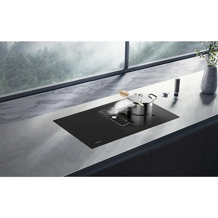 Respekta Induktionskochfeld Calima mit integriertem Dunstabzug - Breite: 83 cm, Schwarz, Max. Gebläseleistung Abluftbetrieb: 544,7 m³/h - Moderner Kochfeldabzug von Bora mit einem Topf darauf, der dampft, und einer Vase mit Dekoration.
