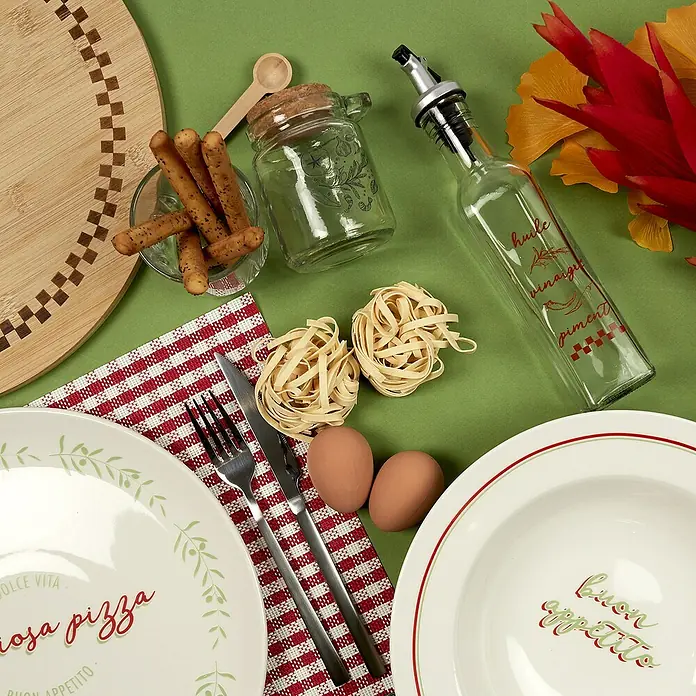 Aceitera y vinagrera - 250 ml, Vidrio, 1 pzs. - Arreglo con platos, cubiertos, huevos, pasta y una botella de aceite sobre un fondo verde. Perfecto para una cena italiana.