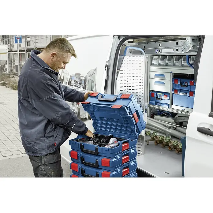 Bosch Professional Systemkoffer L-Boxx 136 - L x B x H: 357 x 442 x 151 mm, ABS - Ein Handwerker öffnet einen blauen Bosch Werkzeugkoffer vor einem Transporter, der mit Regalen und Werkzeugen ausgestattet ist.