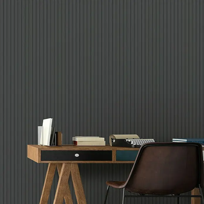 FN Neuhofer Wandpaneel Wally WA030 - Eiche schwarz, 2.670 x 118 x 12 mm - Schreibtisch mit Stuhl vor einer Wand mit vertikalen Streifen. Der Schreibtisch ist mit Büchern und einer Schreibmaschine dekoriert.