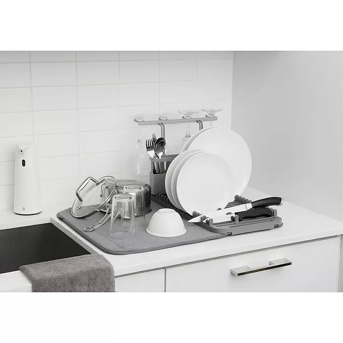 Umbra Abtropfmatte Udry - L x B x H: 61 x 46 x 27 mm, Kunststoff, Grau - Ein graues Kunststoff-Abtropfgestell und passende Mikrofaserunterlage halten weiße Teller, klare Gläser und Besteck.