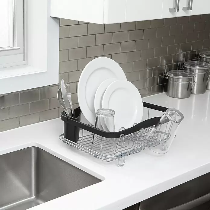 Umbra Abtropfgestell Sinkin - L x B x H: 36 x 29 x 14 cm, Edelstahl, Schwarz/Nickel - Metallenes Geschirrabtropfgestell mit schwarzen Akzenten, das Teller, Besteck und Gläser neben einem Spülbecken hält.