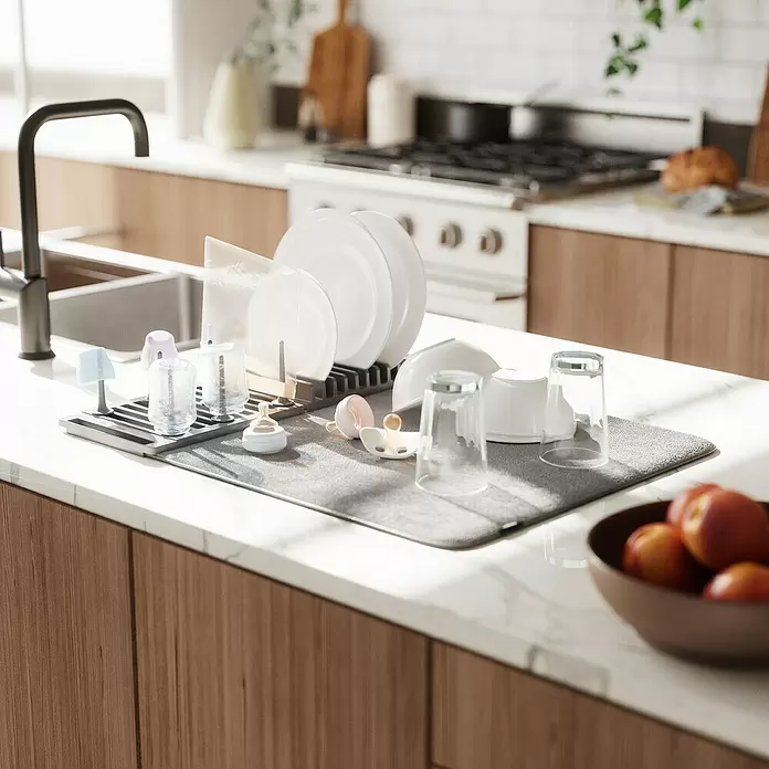 Umbra Abtropfmatte Udry Peg - L x B x H: 47 x 17 x 9 cm, Kunststoff, Anthrazit - Graues Geschirrtrockengestell mit Matte auf Küchenarbeitsplatte neben Spüle, mit Tellern, Gläsern, Babyflaschen.