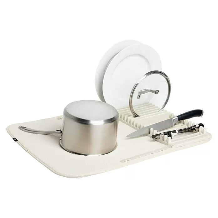Umbra Abtropfmatte Udry - L x B x H: 61 x 46 x 4 mm, Kunststoff, Beige - Ein cremefarbener Geschirrtrockner hält einen silbernen Topf, weiße Teller, einen Glasdeckel, ein Messer und Besteck in einem weißen Gestell.