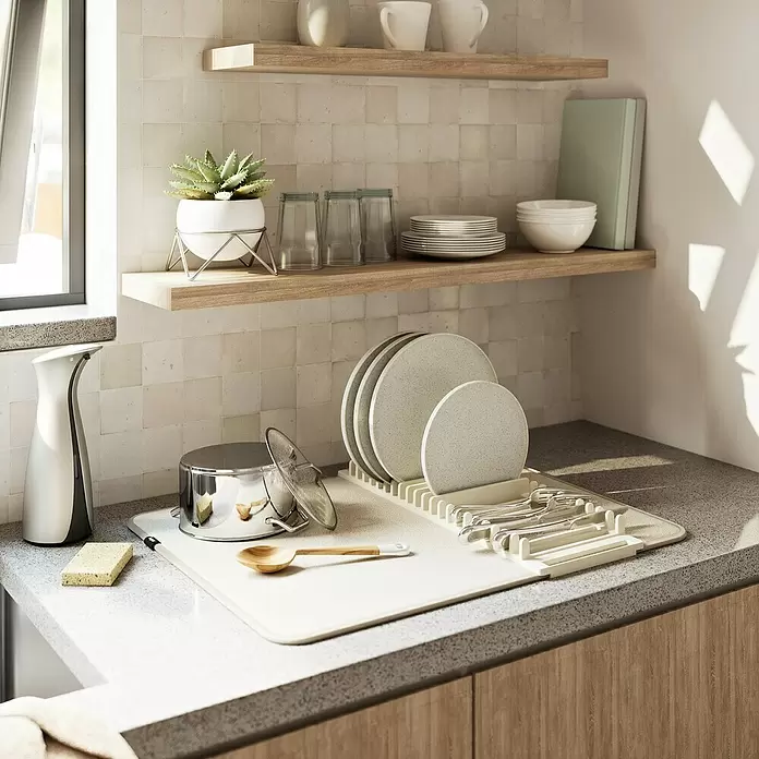 Umbra Abtropfmatte Udry - L x B x H: 61 x 46 x 4 mm, Kunststoff, Beige - Modernes beiges Geschirrtrockengestell auf der Küchenzeile mit Spülgut. Topf, Seifenspender und Schwamm sind daneben.