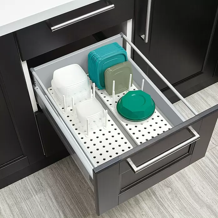 Umbra Schubladeneinsatz-Set Peggy - 45 cm, 15 cm, 1 cm, Weiß - Weißer Schubladen-Organizer mit Stiften für klare und farbige Lebensmittelbehälter und Deckel in einer dunklen Küchenschublade.
