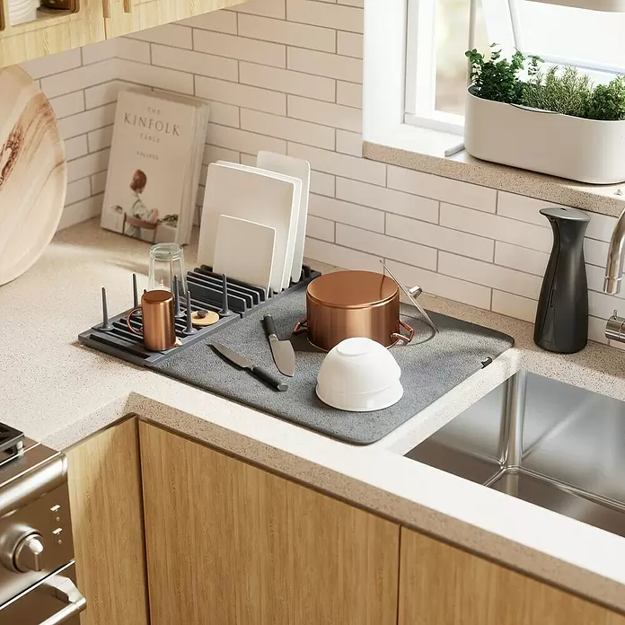 Umbra Abtropfmatte Udry Peg - L x B x H: 47 x 17 x 9 cm, Kunststoff, Anthrazit - Dunkelgraues Abtropfgestell und graue Matte mit Geschirr neben einer Küchenspüle.
