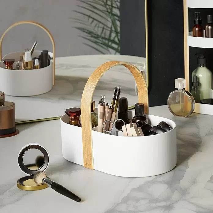 Umbra Aufbewahrungsbox Bellwood - L x B x H: 30 x 20 x 23 cm, Kunststoff, Weiß-Natur - Weißer ovaler Organizer mit Holzgriff, gefüllt mit Kosmetika auf einem Marmorwaschtisch.