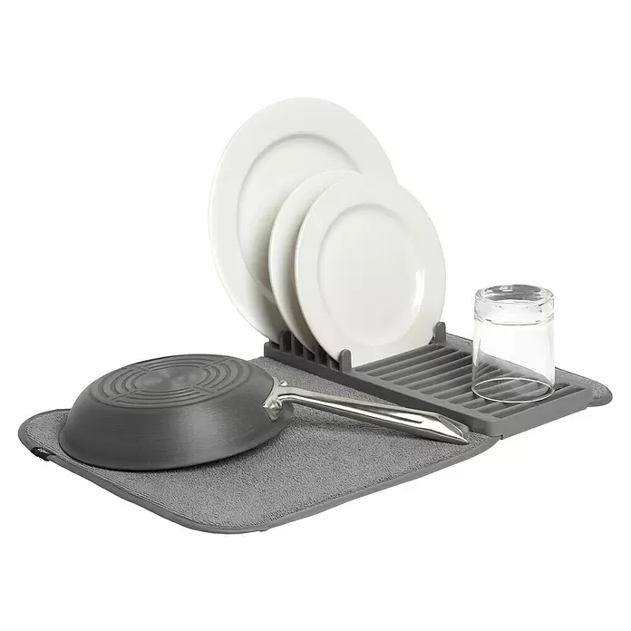 Umbra Abtropfmatte Udry Mini - L x B x H: 33 x 51 x 4 cm, Kunststoff, Anthrazit - Graue Geschirrtrocknermatte mit grauem Gestell, das drei weiße Teller, ein Glas und eine umgedrehte graue Pfanne hält.