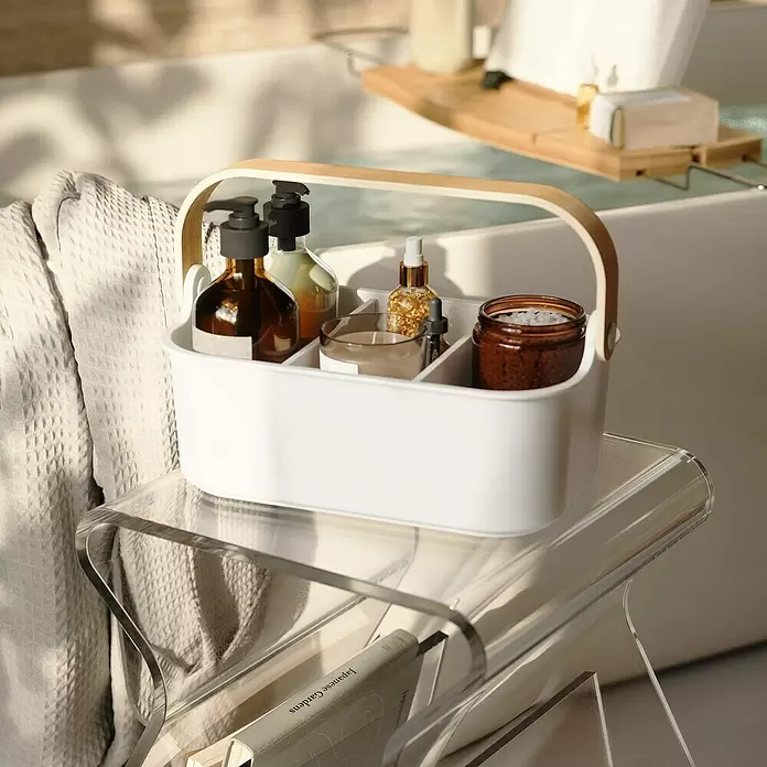 Umbra Aufbewahrungsbox Bellwood - L x B x H: 27 x 12 x 17 cm, Kunststoff, Weiß/Natur - Weißer Caddy mit Holzgriff, gefüllt mit Badezimmerutensilien, in einem ruhigen Badezimmer.
