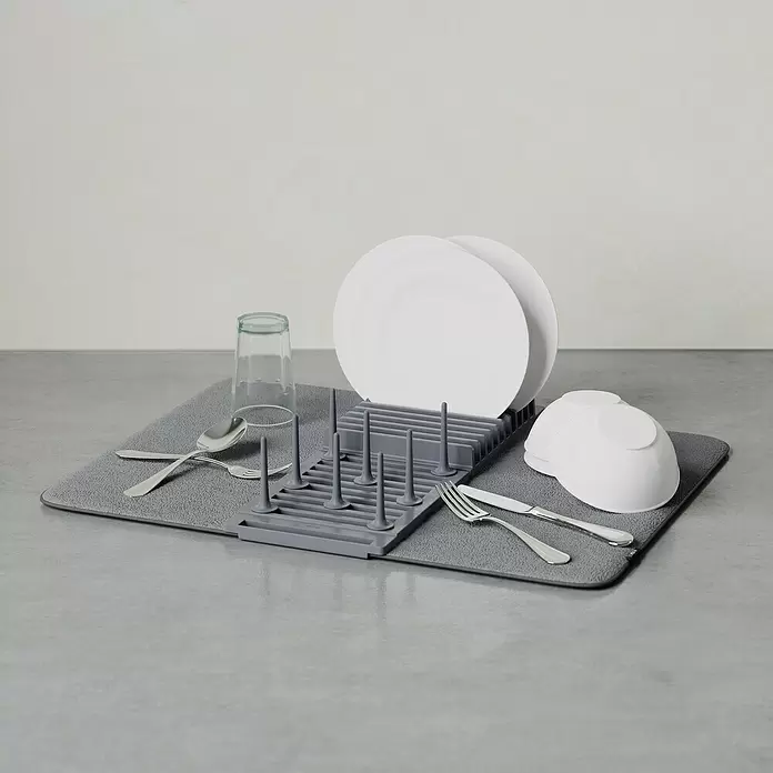 Umbra Abtropfmatte Udry Peg - L x B x H: 47 x 17 x 9 cm, Kunststoff, Anthrazit - Graues Abtropfgestell aus Silikon und Stoffmatte mit weißem Geschirr, Glas und Besteck.