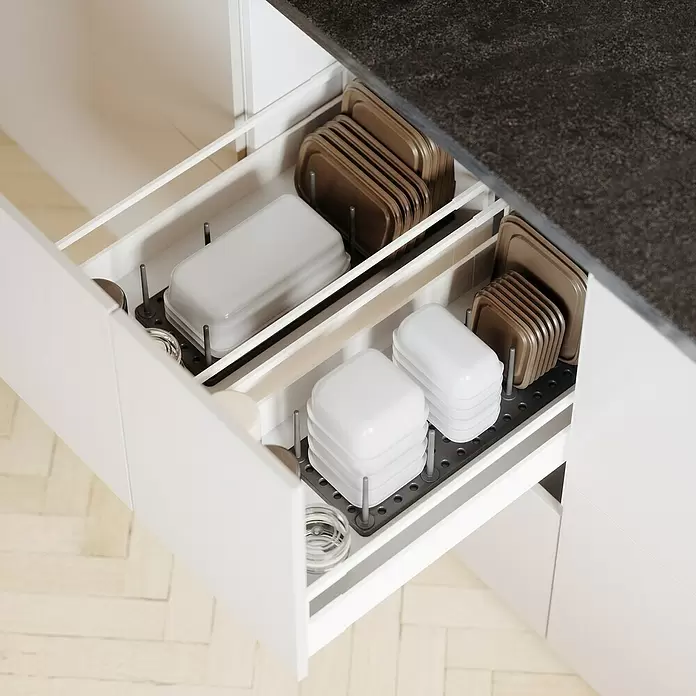 Umbra Schubladeneinsatz-Set Peggy - 45 cm, 15 cm, 1 cm, Grau, 2 Stk. - Geöffnete Küchenschublade mit dunkelgrauen Steckbrett-Organizern, die weiße und hellbraune Vorratsbehälter und Deckel ordentlich anordnen.