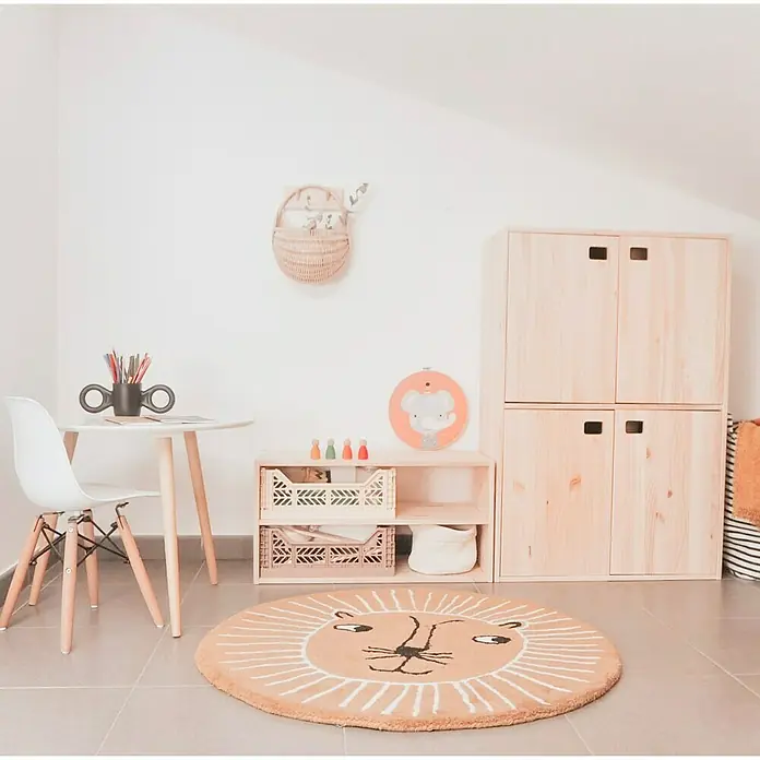 Astigarraga Dinamic Schrank - L x B x H: 33 x 37,3 x 53,5 cm, Kiefernholz - Gemütliches Kinderzimmer mit rundem Löwen Teppich, Holzmöbeln und einem kleinen Tisch mit Stuhl.