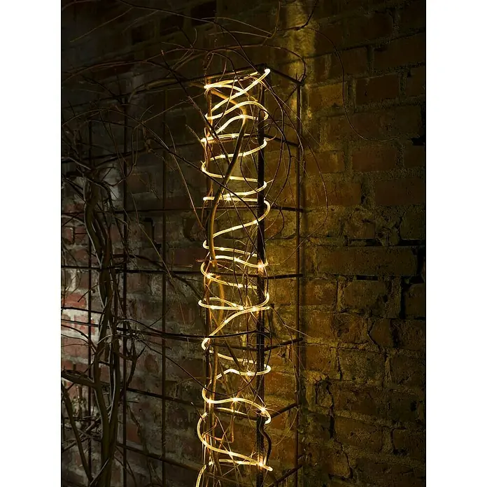 Konstsmide LED-Lichtschlauch -  - Dekorative Lichterkette, spiralförmig um eine Metallstruktur gewickelt, vor einem Backsteinhintergrund. Warme, einladende Beleuchtung.