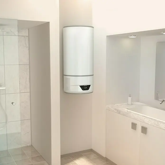Ariston Aerotermo Lydos Hybrid Wifi - 100 l, 1.200 W - Un calentador de agua moderno de pared en un baño elegante. El aparato es blanco y cilíndrico con detalles grises.