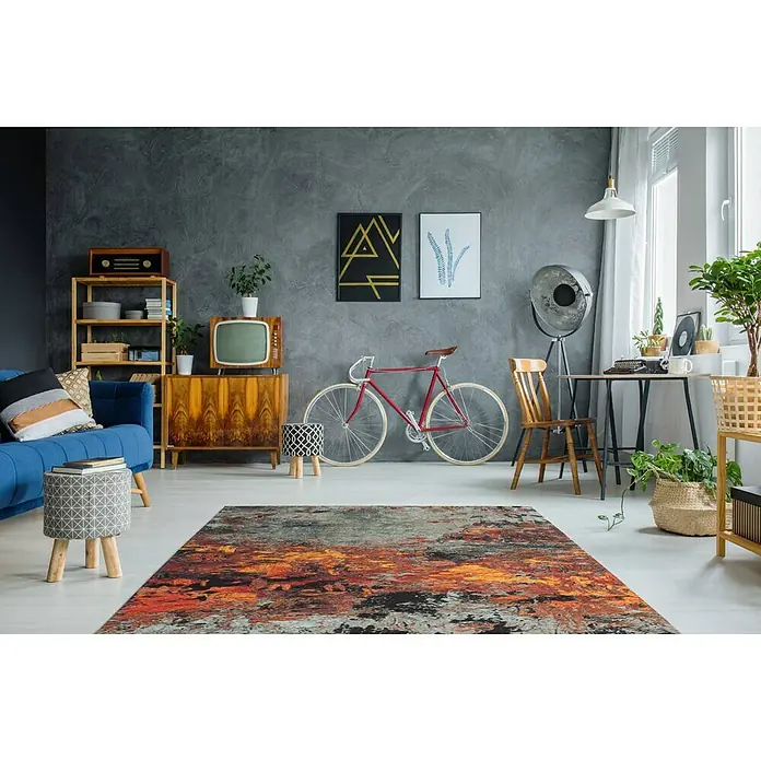 Kayoom Flachgewebeteppich Blaze - Braun/Multi, 170 x 115 cm, 74 % Polyester - Ein Wohnzimmer mit einem auffälligen Teppich in Orange-, Grau- und Schwarztönen, der einen modernen Akzent setzt.