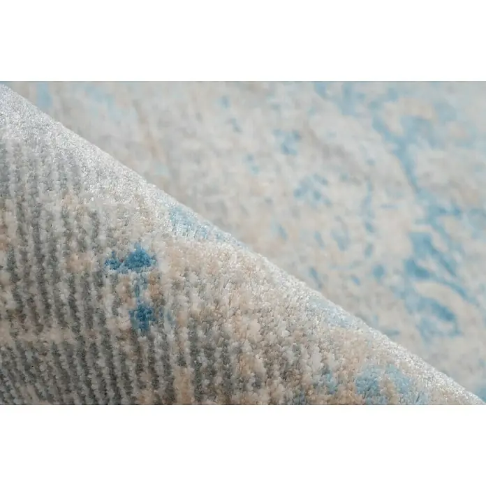 Kayoom Kurzflorteppich Baroque - Beige/Blau, 170 x 120 cm, 100 % Polyester - Detailaufnahme eines hellblauen Teppichs mit zartem Muster, der eine weiche und einladende Textur zeigt.