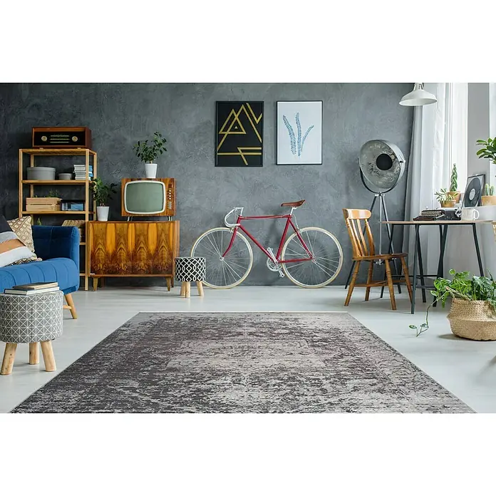 Kayoom Kurzflorteppich Baroque - Braun, 290 x 200 cm, 100 % Polyester - Ein grauer Teppich mit abstraktem Muster liegt in einem stilvollen Wohnzimmer mit Retro-Elementen. Der Teppich verleiht dem Raum eine gemütliche Atmosphäre.
