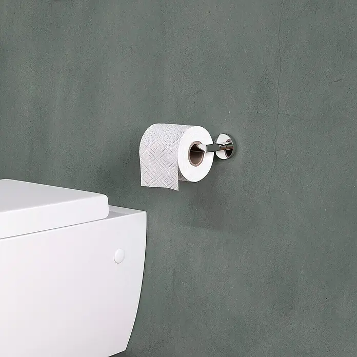 Cosmic Start Portarrollos papel higiénico - Cromo - Una foto de cerca de un portarrollos de papel higiénico con un rollo de papel higiénico al lado en un baño.