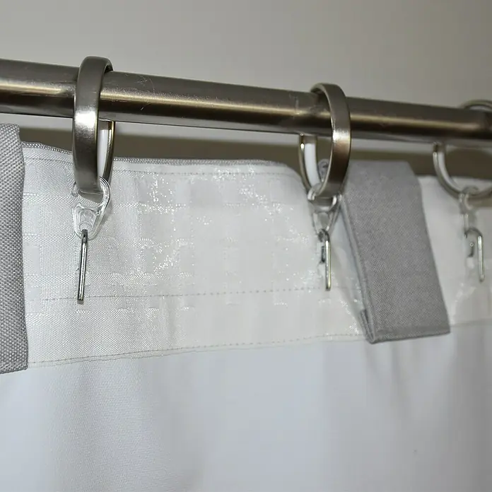 Cortina opaca Termorreguladora - An x Al: 140 x 300 cm, 100% poliéster, Gris - Primer plano de anillas de cortina en una barra con cortinas sujetas, mostrando un diseño elegante y funcional.