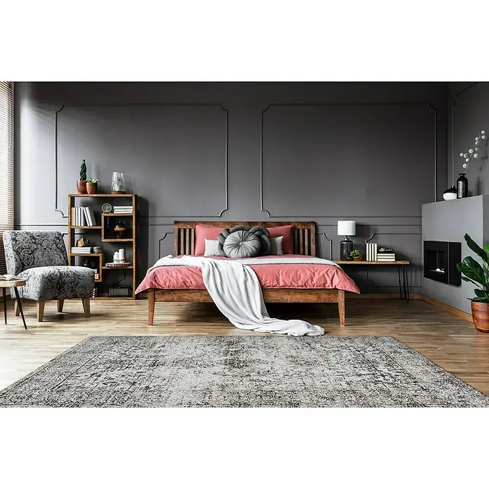 Kayoom Kurzflorteppich Iglesia - Anthrazit, 150 x 80 cm, 100 % Polyester - Ein Schlafzimmer mit einem großen, gemusterten Teppich, einem Holzbett und einem grauen Hintergrund, der eine gemütliche und stilvolle Atmosphäre schafft.