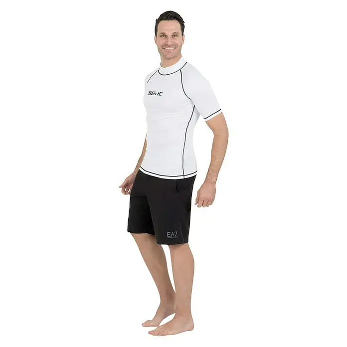 Seac Sub Camiseta térmica T-Sun Short - XXXL, Blanco/Negro, Apto para: Caballeros - Hombre con camiseta SEAC Rash Guard y pantalones cortos negros, descalzo. Ropa de baño ideal para comodidad y protección solar.