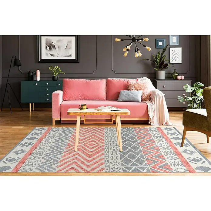 Kayoom Flachgewebeteppich Ethnie I - Grau/Rot, 290 x 200 cm, 100 % Baumwolle - Ein stilvoller Wohnraum mit einem dekorativen Teppich in Grau- und Koralltönen, der das Ambiente des Zimmers hervorhebt.