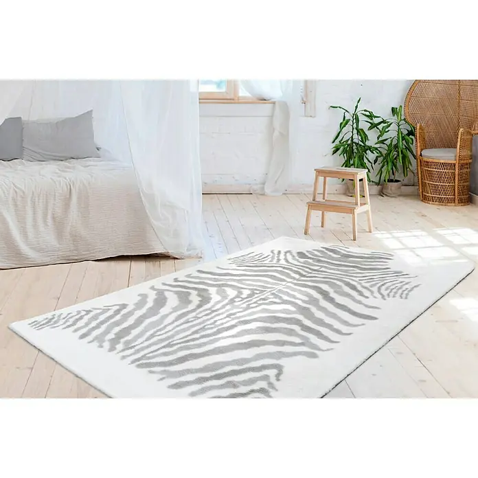 Kayoom Hochflorteppich Zebra - Weiß/Grau, 230 x 160 cm, 100 % Polyester - Ein modernes Zimmer mit einem stilvollen, rechteckigen Teppich mit grauem Zebra-Muster, der den Raum optisch aufwertet.