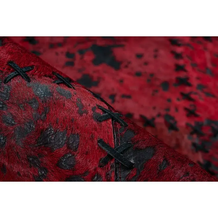 Kayoom Lederteppich Viola - Rot, 290 x 200 cm, 100 % Echtleder - Nahaufnahme eines rot-schwarzen Ledersessels mit auffälligen Kreuzstichdetails, der Textur und handwerkliches Können betont.