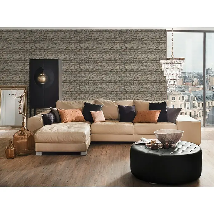 A.S. Création Il Decoro Papiertapete Stein I - Grau/Braun, Steinoptik, 10,05 x 0,53 m - Gemütliches Wohnzimmer mit einem hellen Ledersofa, Zierkissen und einem schwarzen Hocker. Ein elegantes Interieur mit stilvollen Akzenten.