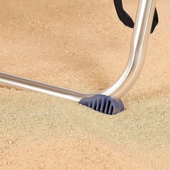 Silla de camping Mykonos - 61 x 50 x 85 cm, Azul, Acero/Textiline - Primer plano de una pata de silla con un pie azul sobre arena, diseñada para estabilidad. La pata metálica garantiza durabilidad.