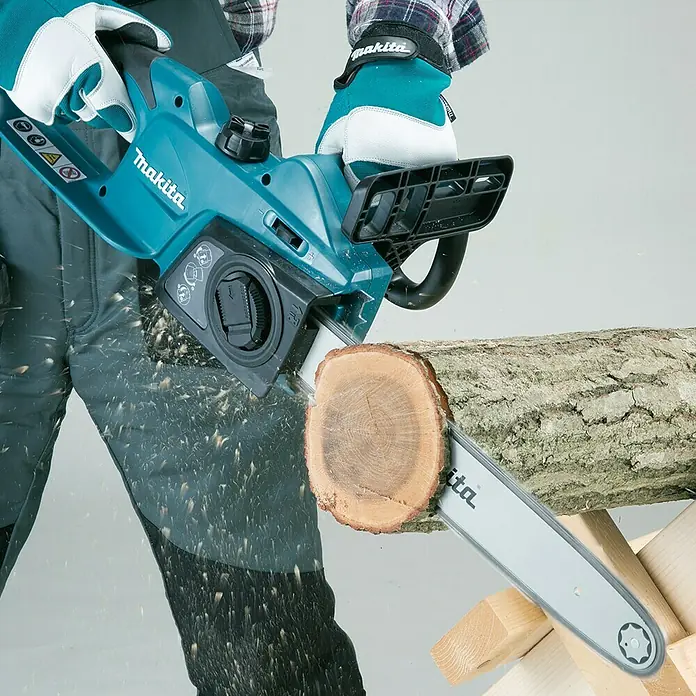 Makita Motosierra eléctrica UC4041A - 1.800 W, Longitud de la cuchilla: 40 cm - Motosierra Makita a batería cortando un tronco, ideal para jardinería y proyectos de carpintería.