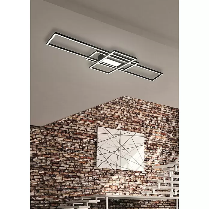 Trio Lighting Plafón LED Irvine - 60 W, L x An x Al: 6,5 x 105 x 42 cm, Blanco - Lámpara de techo LED rectangular moderna en blanco y negro, instalada en un techo gris claro en una habitación con pared de ladrillo y escalera blanca.