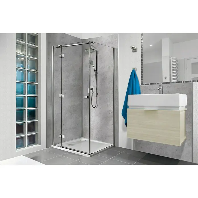 SanDesign Alu-Verbundplatte - 100 x 250 cm, Beton - Elegante Badezimmeransicht mit einer modernen Duschkabine mit klaren Glaswänden und Chromrahmen. Ein Waschbecken und ein Spiegel runden das Design ab.