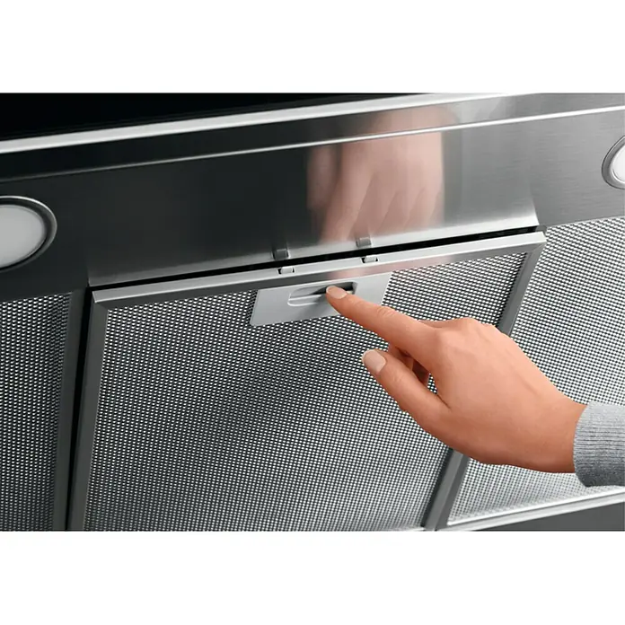Electrolux Campana de pared LFT766X - Ancho: 59,8 cm, Máx. Potencia del ventilador en modo extracción: 720 m³/h, Acero inoxidable - Primer plano de una campana extractora, donde una mano acciona el interruptor para ajustar la configuración. Diseño elegante para cocinas modernas.