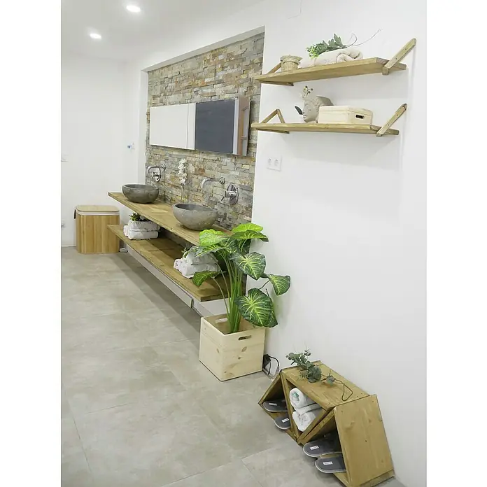 Astigarraga Triangle Soporte de estanterías - L x Al: 20 x 20 cm, Carga soportada: 20 kg, Natural - Un baño con estantes de madera natural, una pared de azulejos de piedra y lavabos de cerámica gris. Una planta en maceta da vida al espacio.