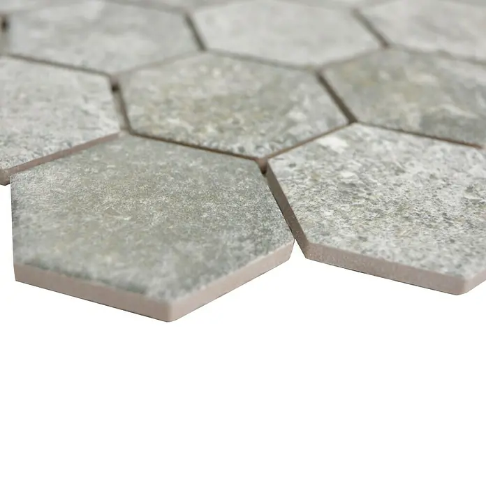 Mosaikfliese Hexagon HX CURIO GG - 32,5 x 28,1 cm, Grau, Matt - Nahaufnahme von sechseckigen grauen Fliesen mit gesprenkelter Textur, die ein attraktives und modernes Designelement für den Innenraum bieten.