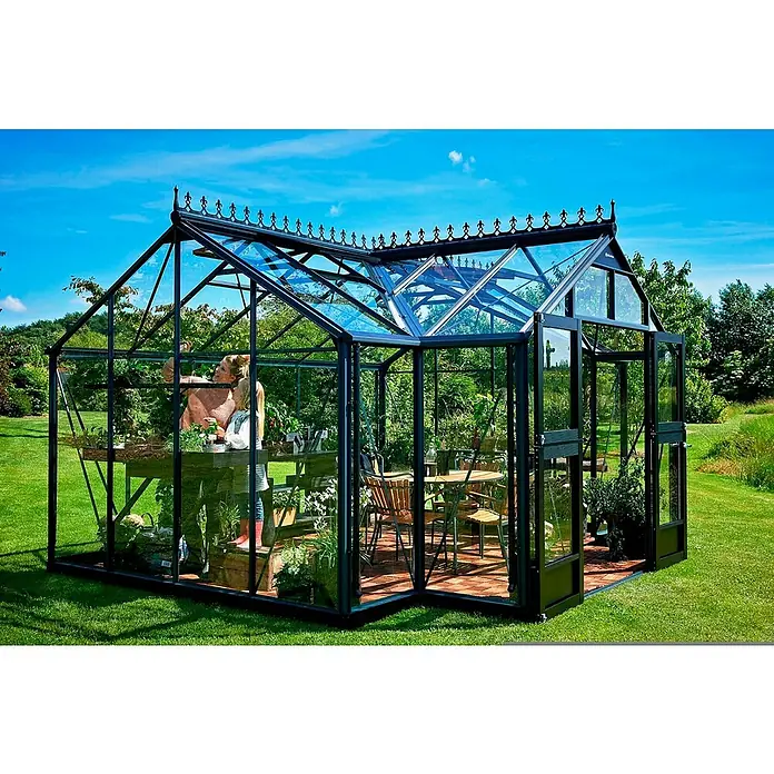Juliana Gewächshaus Orangerie - Außenmaß inkl. Dachüberstand (B x T): 439 x 373 cm, Material Seitenwand: Glas, 3 mm, Anthrazit/Schwarz - Das Bild zeigt ein elegantes Gewächshaus mit Pflanzen und Möbeln, das einen idyllischen Rückzugsort im Garten bietet.