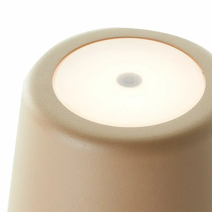 Brilliant Akku-Tischleuchte Kaami - 2 W, Cappuccino, Warmweiß - Nahaufnahme einer beigen kabellosen LED-Tischleuchte mit einem runden, leuchtenden Bedienfeld und einem Ein-/Ausschalter in der Mitte.